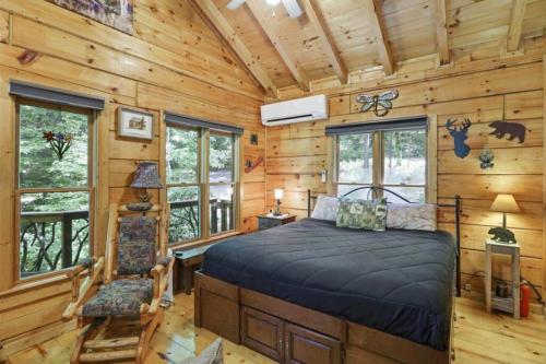 ein Schlafzimmer mit einem Bett in einem Blockhaus in der Unterkunft Open Studio Lodge at Little Rock Creek in Cherry Log