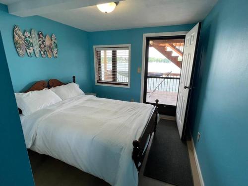 a blue bedroom with a large bed and a window at Lakin' It Easy in Middlebury