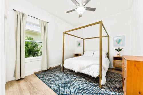 ein Schlafzimmer mit einem Himmelbett und einem Fenster in der Unterkunft New Construction-Heated Saltwater Pool, Sauna, and Game Room! in Jensen Beach