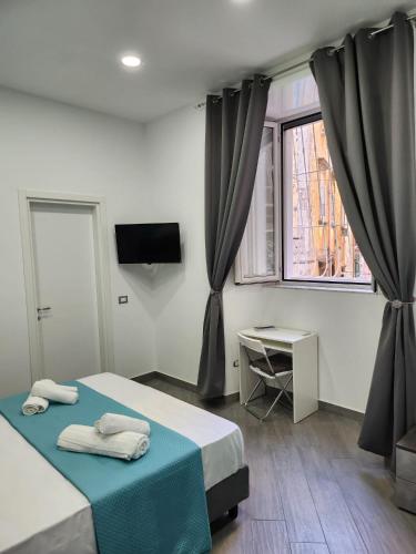 a bedroom with a bed and a desk and a window at Gradini Partenopei in Naples