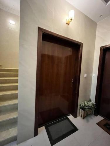 duże drewniane drzwi w budynku ze schodami w obiekcie شقة مميزه في القنفذة w mieście Al Qunfudhah