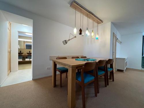 a dining room with a wooden table and chairs at MARYS family friendly Apartments,VISIT RHINE FALLS for FREE if you stay 2 nights, SOHO 95m2 2-Bedrooms 2nd floor & SOUTH BEACH 105m2 3-Bedrooms & LOFT 115m2 3-Bedrooms Suite with Galerie,LOFT Netz 20m2, Pinball, Schaffhausen-Hemmental, Rheinfall 10 km in Schaffhausen