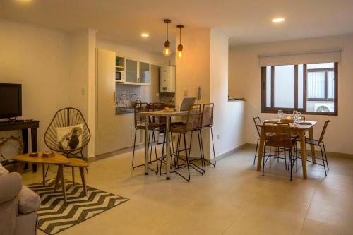 Una sala de estar con mesa y sillas y una cocina. en Espacio Maipú, en Salta