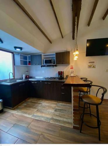 a kitchen with a table and chairs and a counter at aparta estudio turístico in Salento