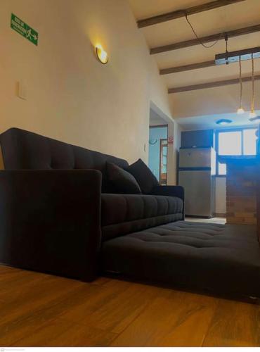 a living room with a black couch in a room at aparta estudio turístico in Salento