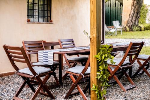 a wooden table and chairs on a patio at CASENUOVE II - Casale con parco e piscina in Castiglioncello