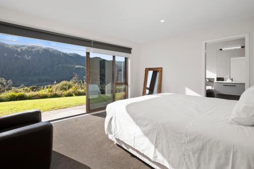 um quarto com uma cama branca e uma grande janela em Lakehouse Retreat - Whakamaru Holiday Home em Mangakino