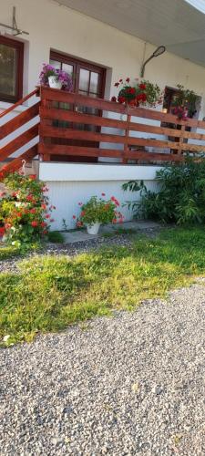 une maison avec une clôture ornée de fleurs dans l'établissement Casa Rodica, à Vatra Dornei
