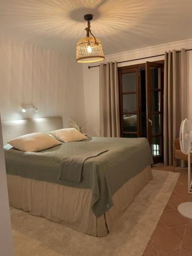 a bedroom with a bed and a chandelier at Lägenhet med 3 sovrum i sagolika byn - LaHeredia in Benahavís