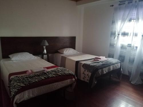 a hotel room with two beds and a window at Casa dos biscoitos in Madalena