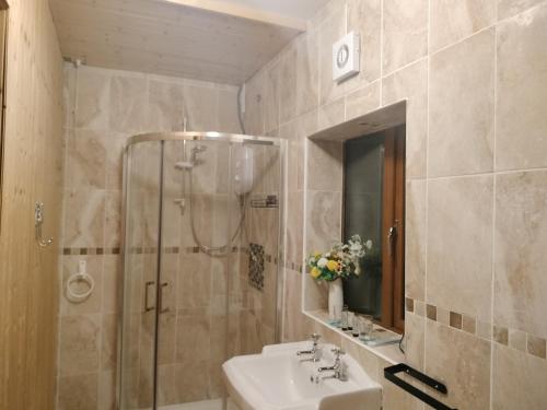 ein Bad mit einem Waschbecken und einer Dusche in der Unterkunft Self Catering apartment Achill Island Pets Allowed in Westport