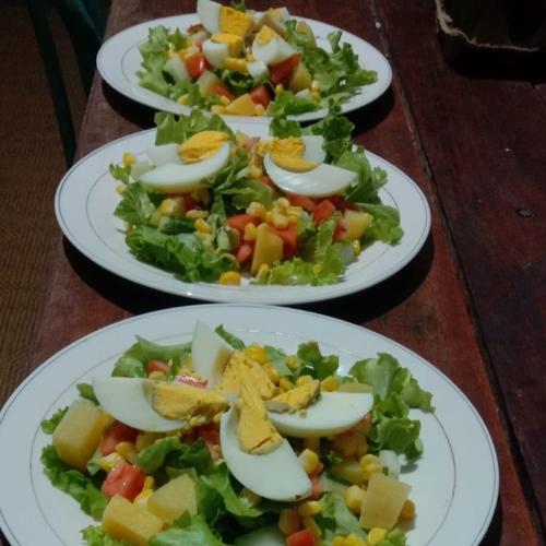 three plates of salad and eggs on a table at Raja Ampat Sandy Guest House in Saonek