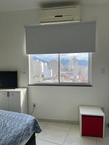 una camera da letto con finestra affacciata sulla città di Fioravante's Apartment a Rio de Janeiro