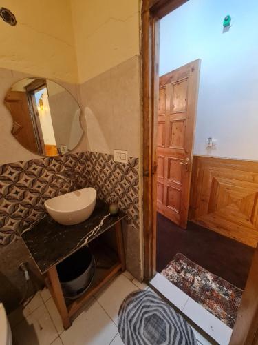 a bathroom with a sink and a mirror at anavrin in Jibhi