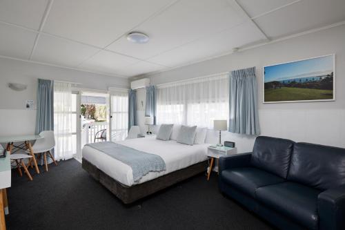 タウランガにあるアシュア ハーバー ビュー モーテルのベッドルーム(ベッド1台、ソファ付)