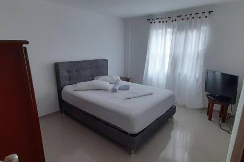 een slaapkamer met een bed en een televisie in een kamer bij Casa hotel Armenia in Armenia