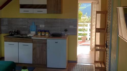 eine Küche mit einem weißen Kühlschrank im Zimmer in der Unterkunft Marković Apartments (vidikovac) in Donji Milanovac