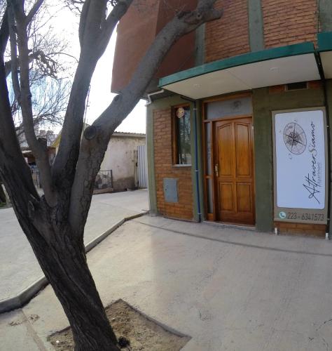 a building with a tree in front of a door at Attraversiamo in Malargüe
