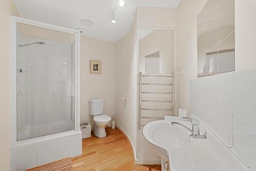 une salle de bain blanche avec un lavabo et des toilettes dans l'établissement Centre Stage - Stroll to the Waterfront, à Hobart