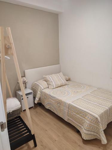 ein kleines Schlafzimmer mit einem Bett und einer Leiter in der Unterkunft VUT La Villa in Vilagarcia de Arousa