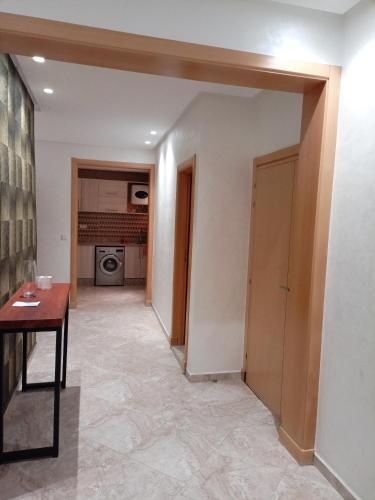 corridoio di una camera con tavolo e porta di شقة مفروشة a Zemmour Touirza
