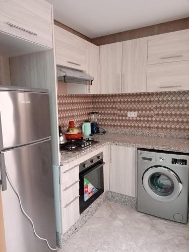 una cucina con frigorifero e lavatrice di شقة مفروشة a Zemmour Touirza