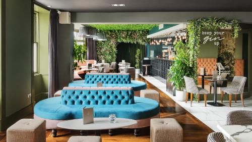 a restaurant with blue seats and tables and chairs at Hotel Indigo - Edinburgh - Princes Street by IHG in Edinburgh
