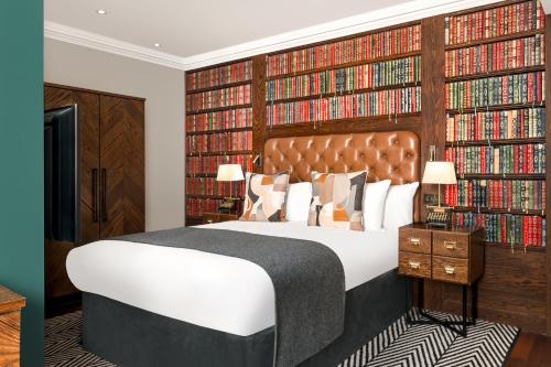 a bedroom with a large bed and a large wall of books at Hotel Indigo - Edinburgh - Princes Street by IHG in Edinburgh