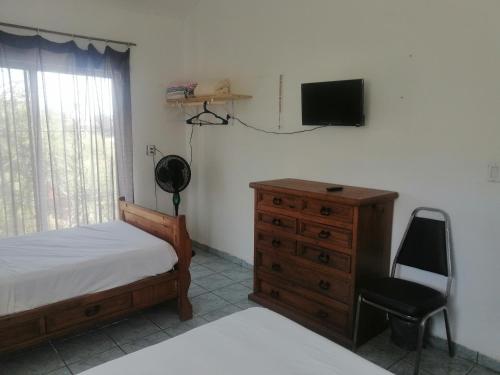 1 dormitorio con 1 cama, vestidor y TV en Casa Las Animas en El Carmen