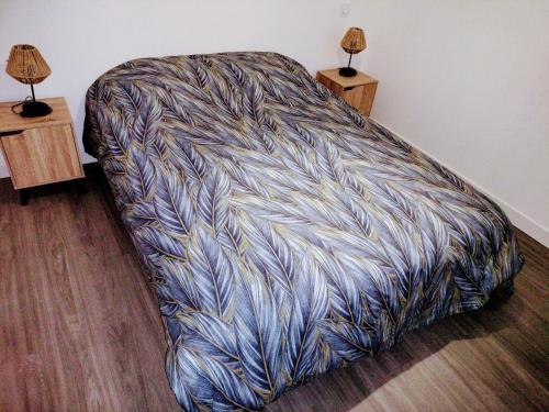 un lit dans une chambre avec deux lampes sur des tables dans l'établissement Petite Maison Cosy en Baie, à Hillion