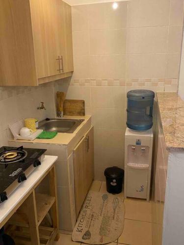 uma pequena cozinha com um lavatório e um frigorífico em The Manna Place - South B em Nairobi