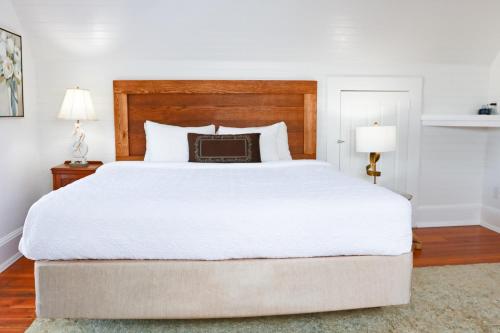 a bedroom with a large white bed and two lamps at Summit Street Inns in Winston-Salem