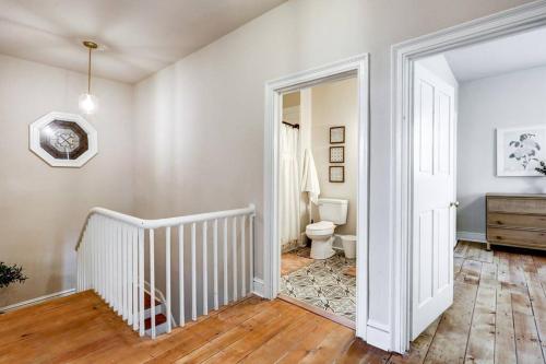 a white bathroom with a toilet and a staircase at Victorian Manor on Main w 6 beds-10 mins to Lanc in Mountville