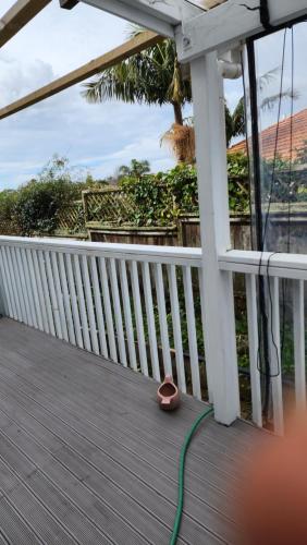 a green hose is sitting on a deck at Bed & Breakfast @ Unsworth Heights Albany in Auckland