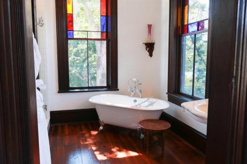 a bathroom with a tub and a sink and stained glass windows at Summit Street Inns in Winston-Salem