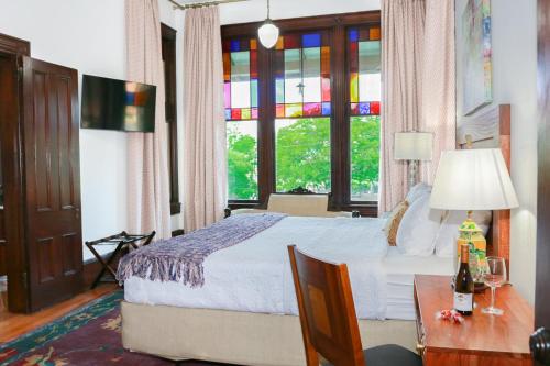 een slaapkamer met een bed, een tafel en een raam bij Summit Street Inns in Winston-Salem