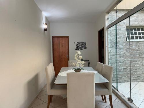 uma sala de jantar com uma mesa branca e cadeiras em crika casa em Aparecida