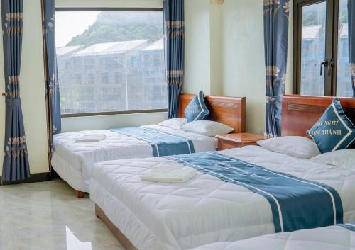 a hotel room with three beds and a window at Long Thanh Hotell in Cat Ba