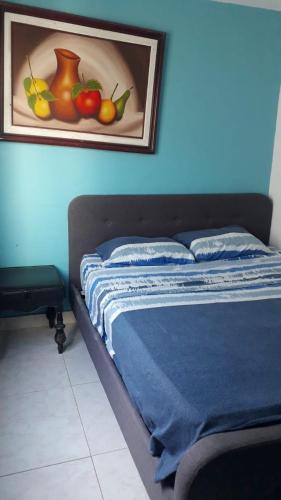 Casa Amplia Completa Privada para Familias في سانتا مارتا: غرفة نوم مع سرير مع لوحة للفواكه على الحائط