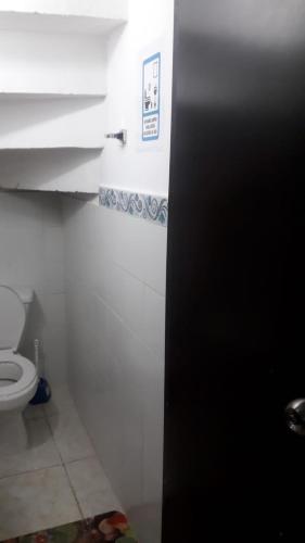 baño con aseo y puerta negra en Casa Amplia Completa Privada para Familias en Santa Marta