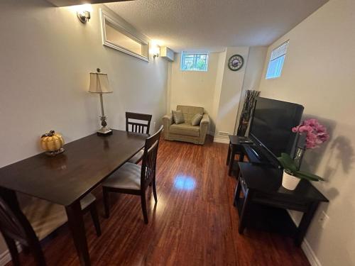 - un salon avec une table, des chaises et un canapé dans l'établissement Basement apartment, à Colline De Richmond