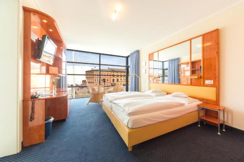 a hotel room with a bed and a television at Hotel Kontorhaus Stralsund in Stralsund