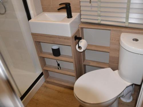 a small bathroom with a toilet and a sink at Brand new chalet on a completely new luxury resort 
