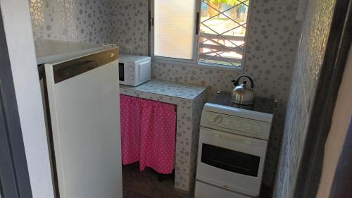 eine kleine Küche mit einem Herd und einer Mikrowelle in der Unterkunft África in General Enrique Martínez
