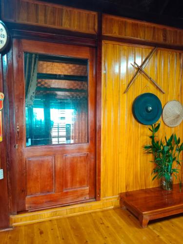 a room with a wooden door and a clock on a wall at homestay phô núi suôi giang in Yên Bái