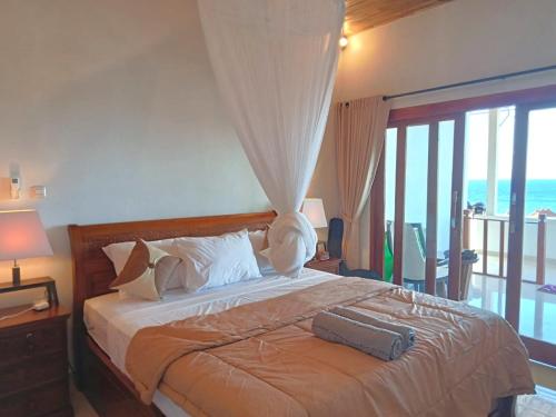 a bedroom with a bed with a view of the ocean at Raweg Studio in Amed