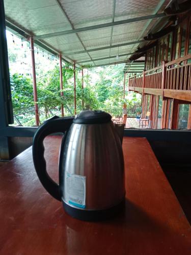 a tea kettle sitting on a wooden table at homestay phô núi suôi giang in Yên Bái
