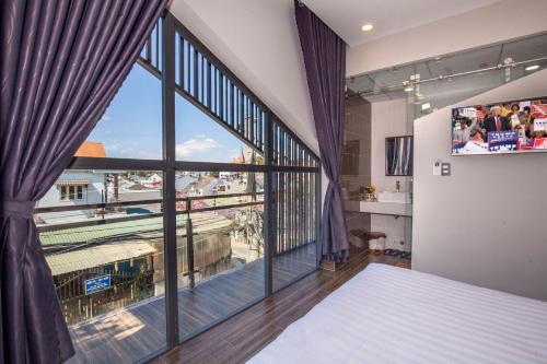Schlafzimmer mit einem großen Fenster mit Aussicht in der Unterkunft Thiên Trang Hotel Đà Lạt in Da Lat