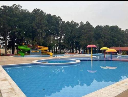 a swimming pool with umbrellas and a water park at Casa Pinatar en condominio in Santa Cruz de la Sierra