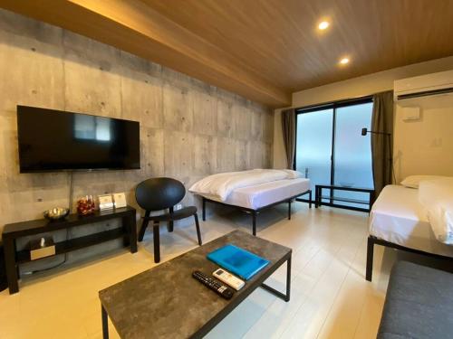 熊本市にあるリブレ in Kumamoto 201のベッド2台、薄型テレビが備わるホテルルームです。